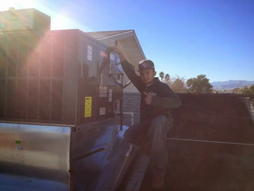 HVAC technician performing AC Tune-Up on a rooftop unit in Annandale